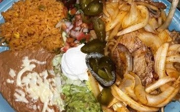 Carnitas dinner with rice, beans and grilled onions